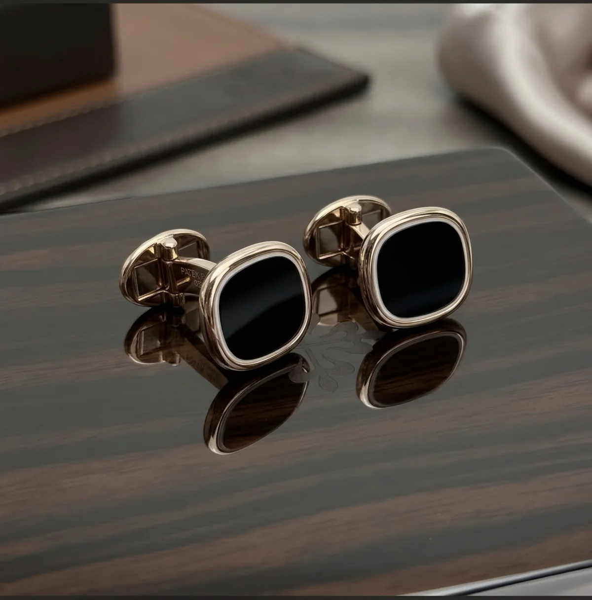 Patek Philippe Black Square Cufflinks — pair displayed on a reflective presentation surface